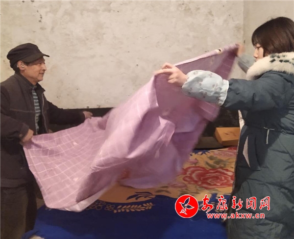 幫扶干部幫馬根元換上新的床單被罩.jpg